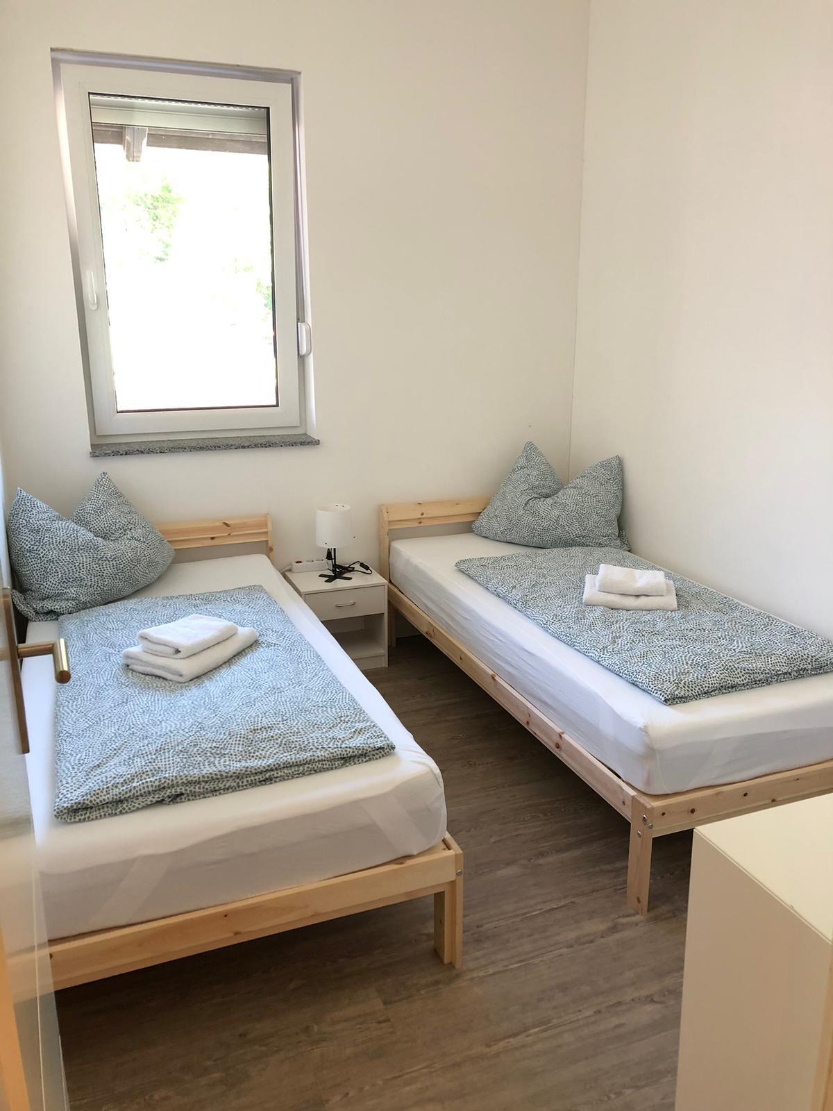 Zwei-Bett-Zimmer mit Einzelbetten aus Holz und Fenster – Vilstal Apartment 2 in Reisbach/Altersberg