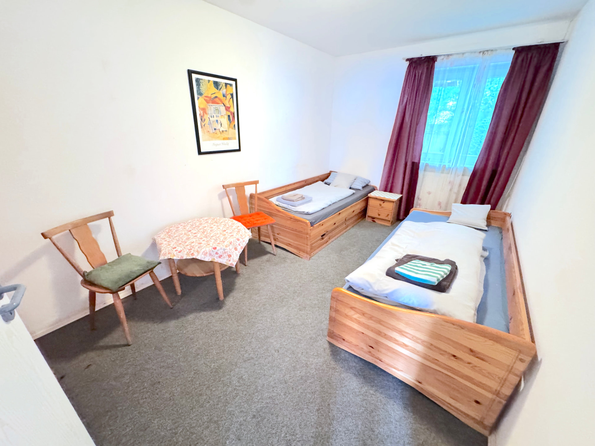Zwei-Bett-Zimmer mit Holzbetten, Tisch und Stühlen in Apartment IV Mettenhausen