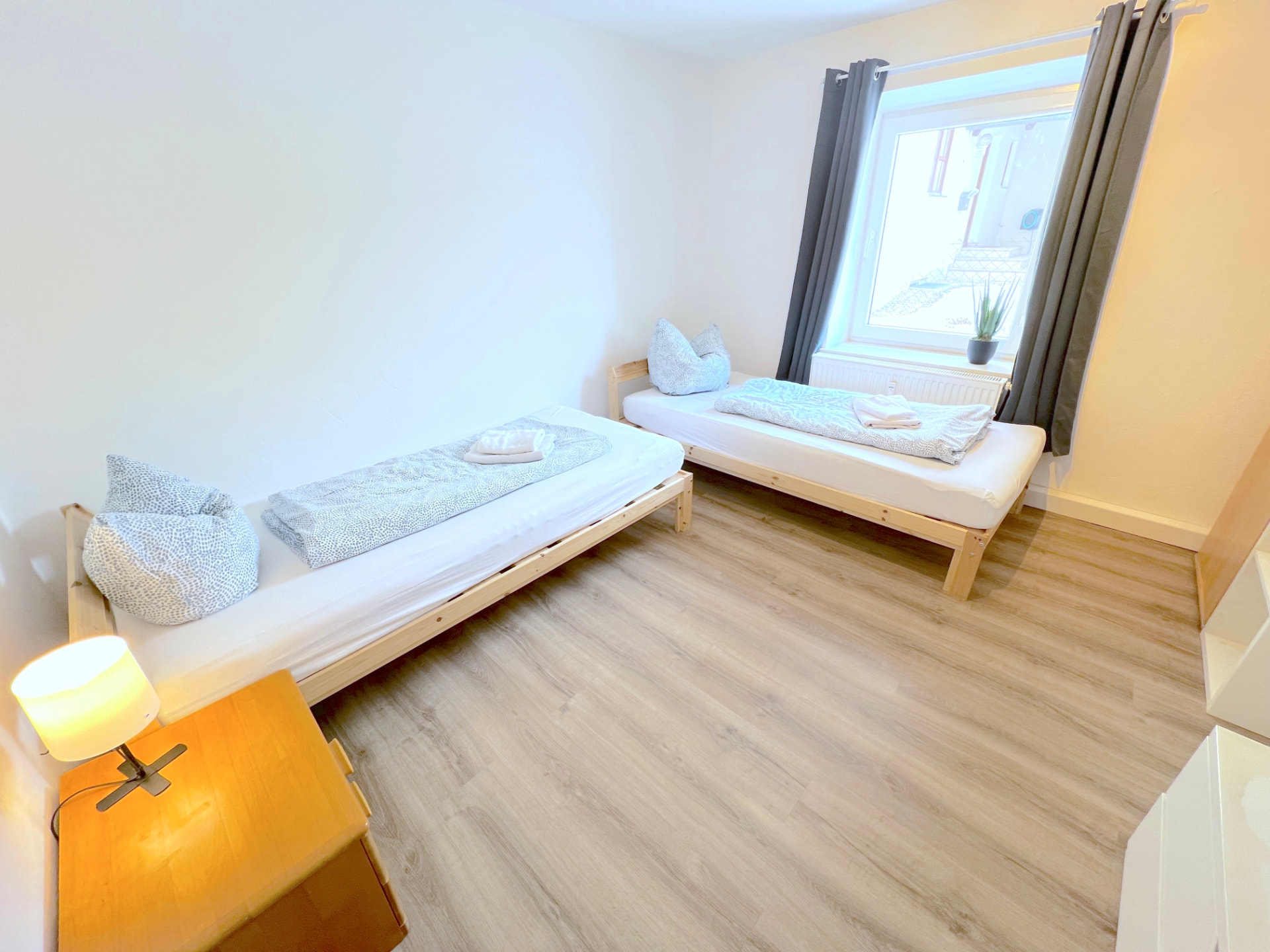 Zwei-Bett-Zimmer mit Holzbetten, Kommode und Fenster in Apartment II Großköllnbach