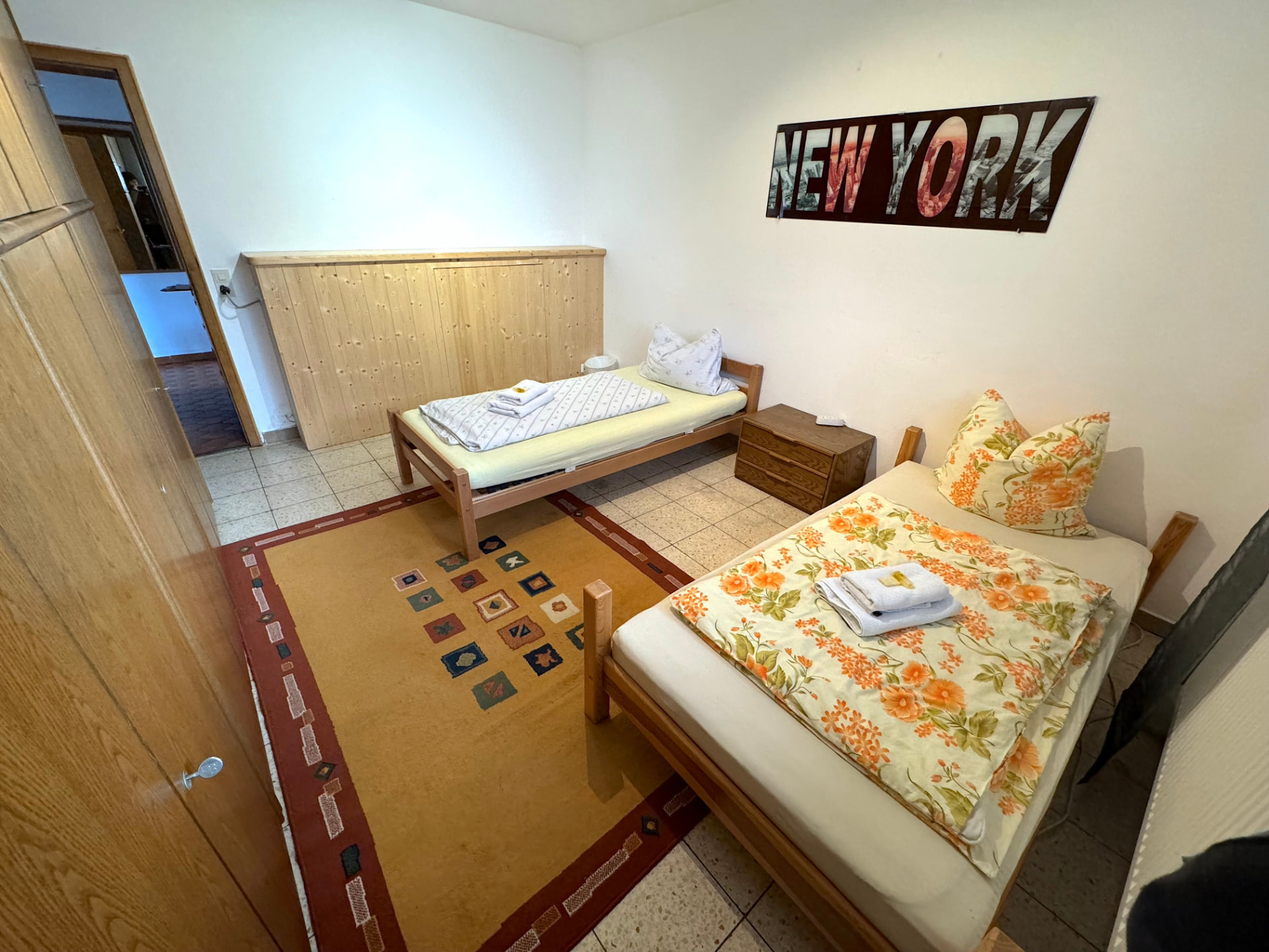 Zimmer mit zwei Einzelbetten, Kommode und Teppich in Apartment II Griesbach