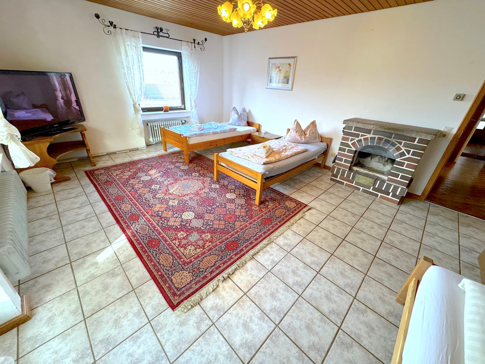 Großer Wohn- und Schlafraum mit Kamin, TV und zwei Einzelbetten in Apartment II Griesbach