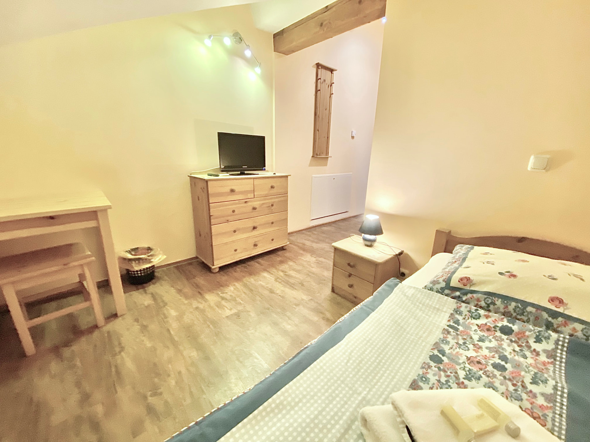 Doppelzimmer mit Kommode, TV und Schreibtisch in der Pension Laurent Ranch Gottfrieding