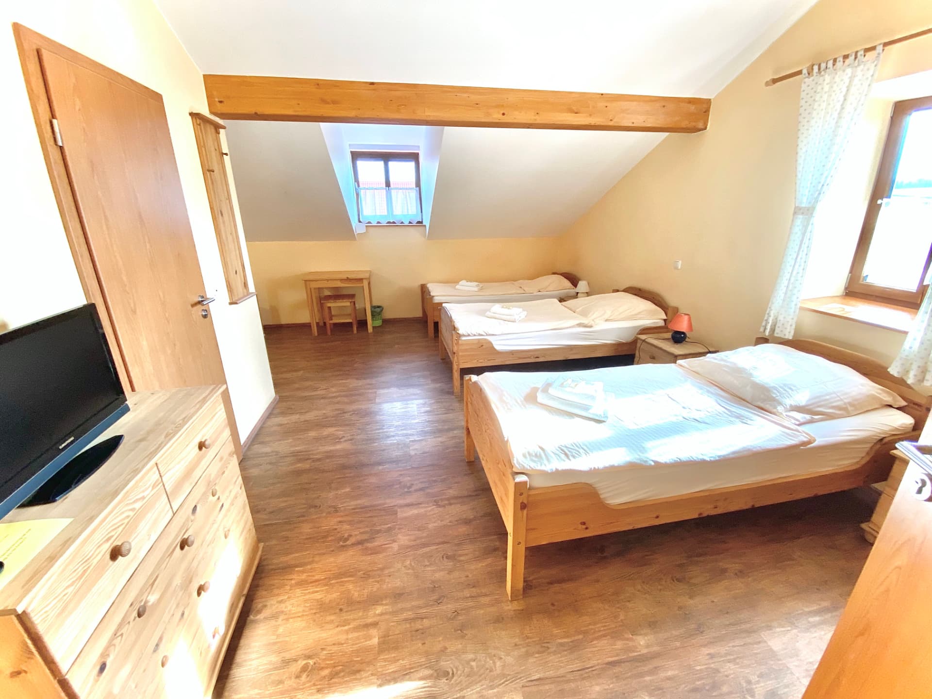 Mehrbettzimmer mit vier Betten und Sitzbereich in der Pension Laurent Ranch Gottfrieding