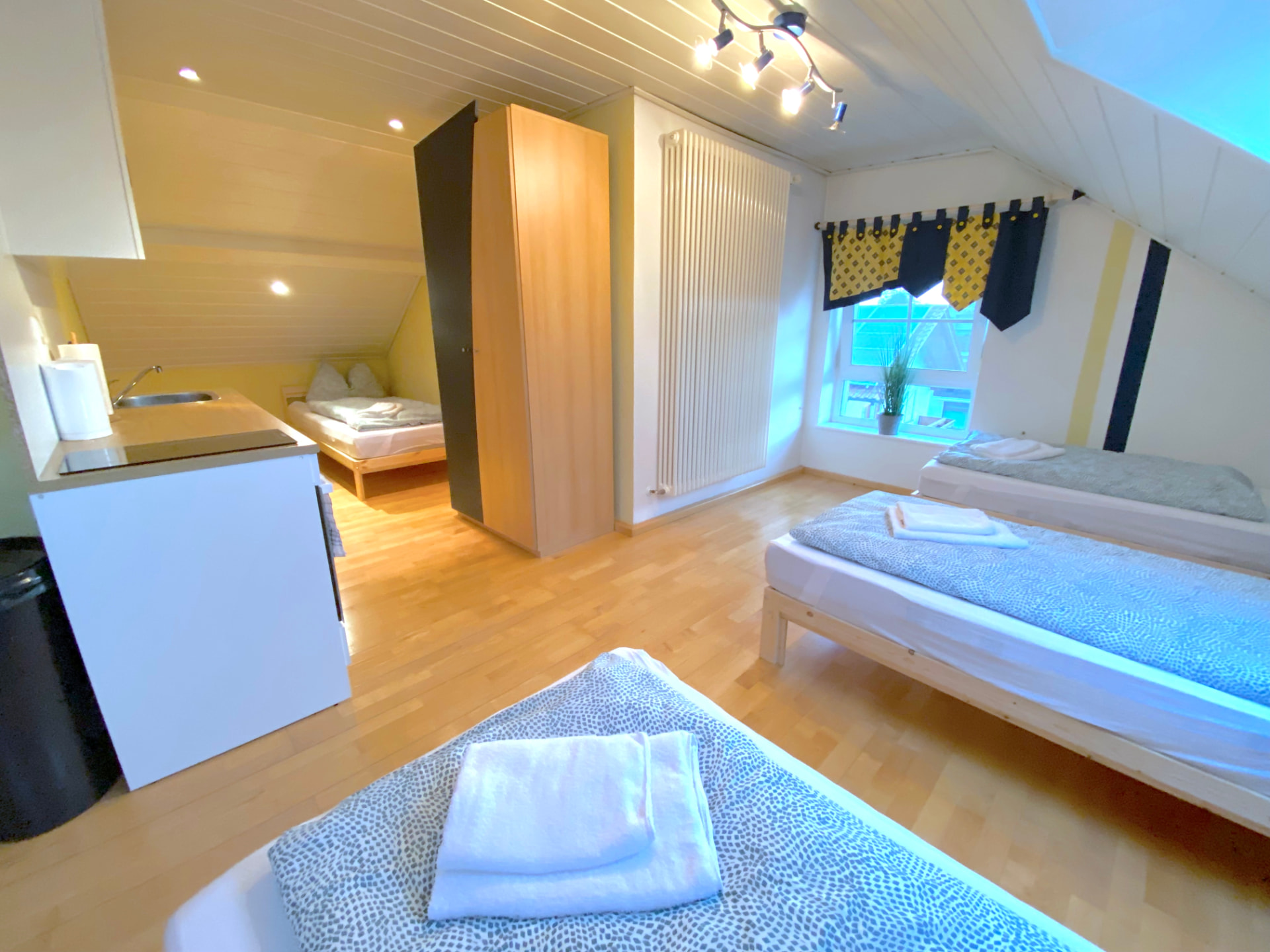 Studio-Apartment V in Kronwieden – Wohnbereich mit Betten, Küchenzeile und Kleiderschrank