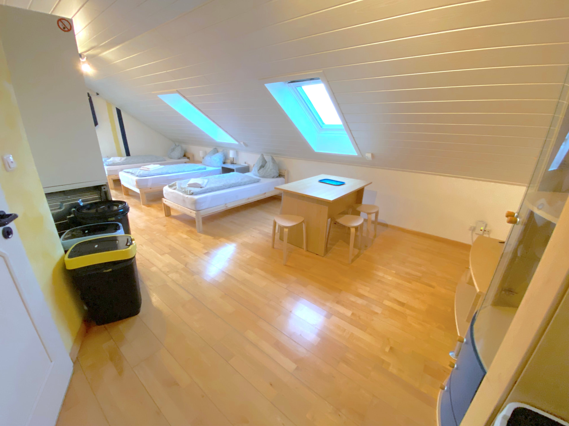 Studio-Apartment V in Kronwieden – Studio mit Betten, Esstisch und Hockern unter der Dachschräge