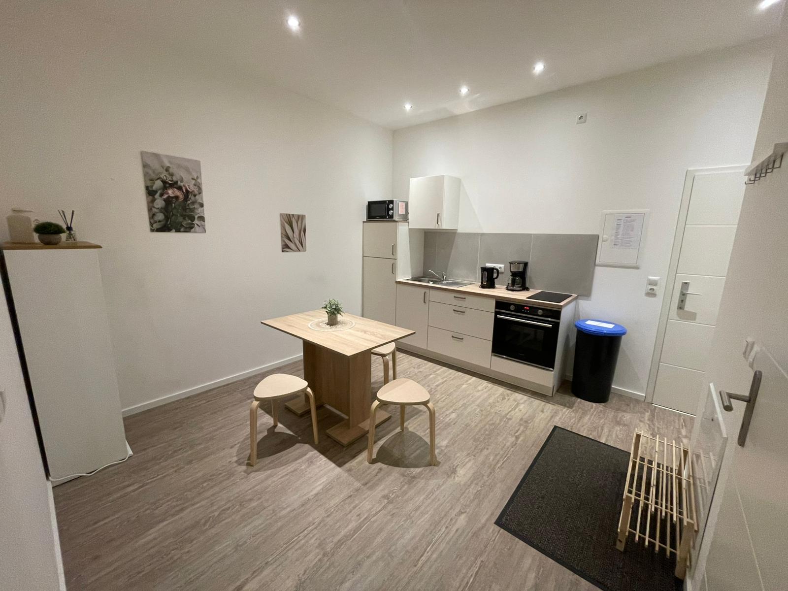 Wohnküche mit Küchenzeile, Backofen, Esstisch und Hockern – Vilstal Apartment 3 in Reisbach/Altersberg