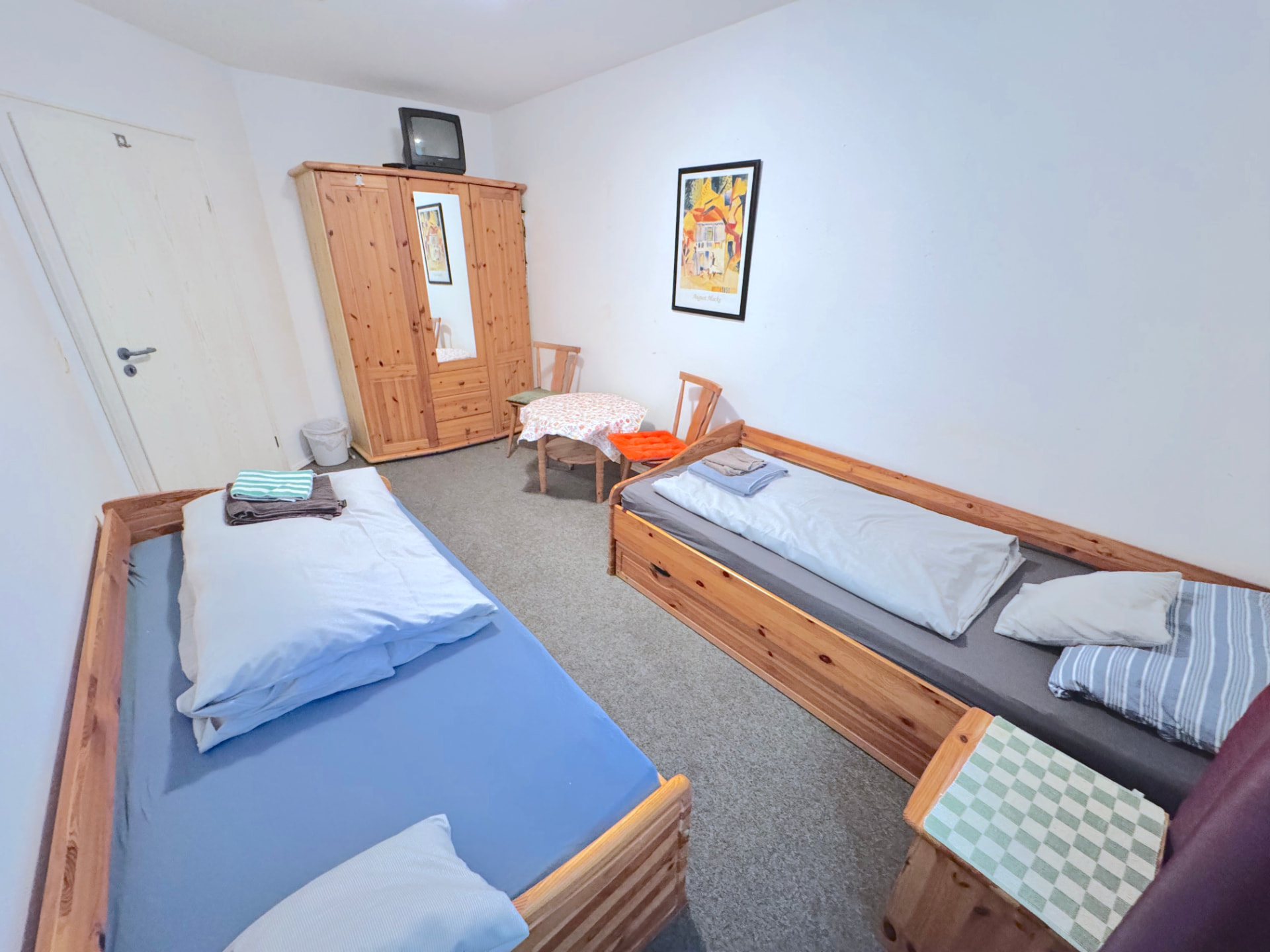 Zwei-Bett-Zimmer mit Kleiderschrank, TV und Sitzecke in Apartment IV Mettenhausen