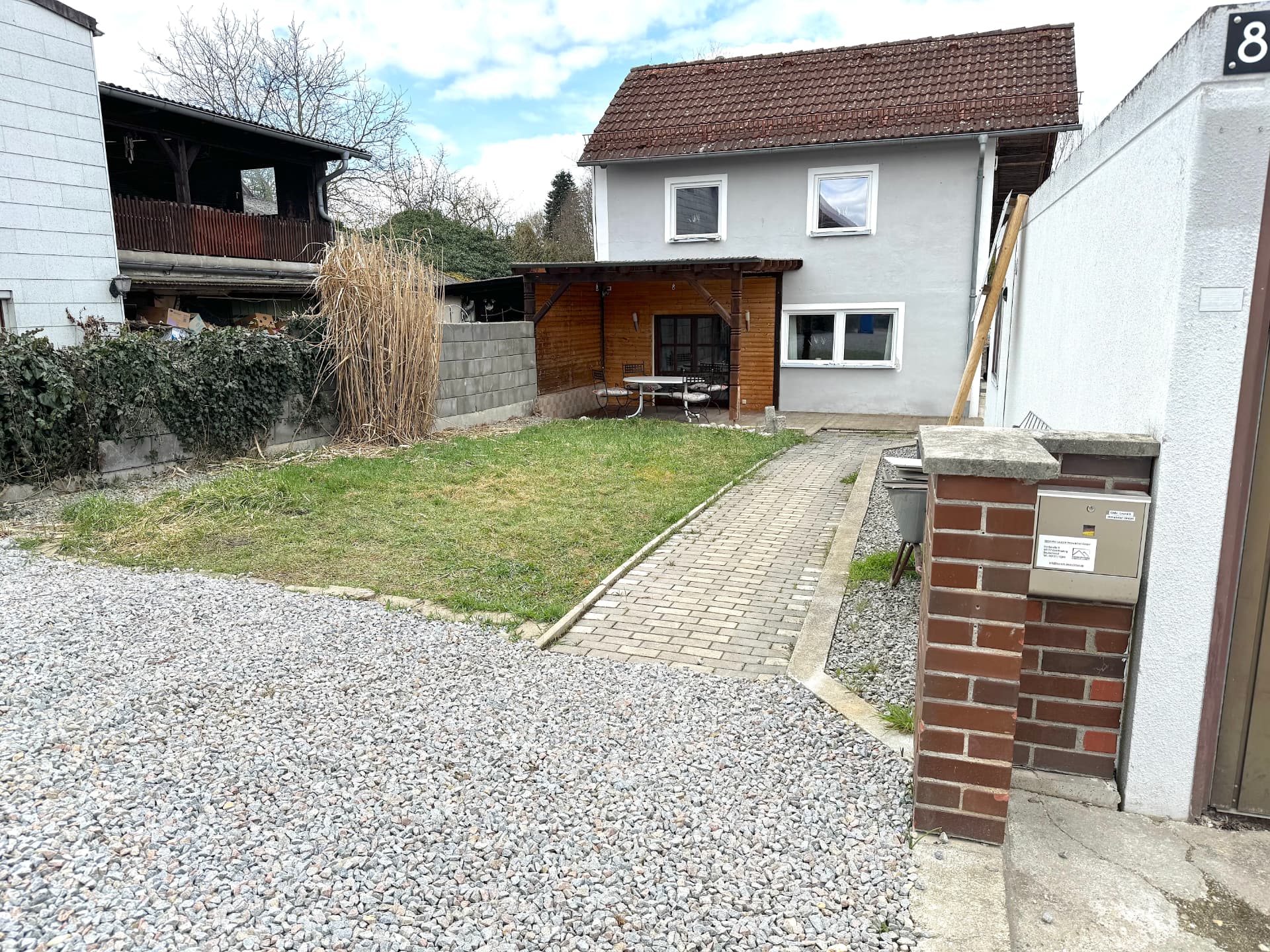 Gartenansicht des Apartmenthauses in Frontenhausen mit Terrasse und Zufahrt