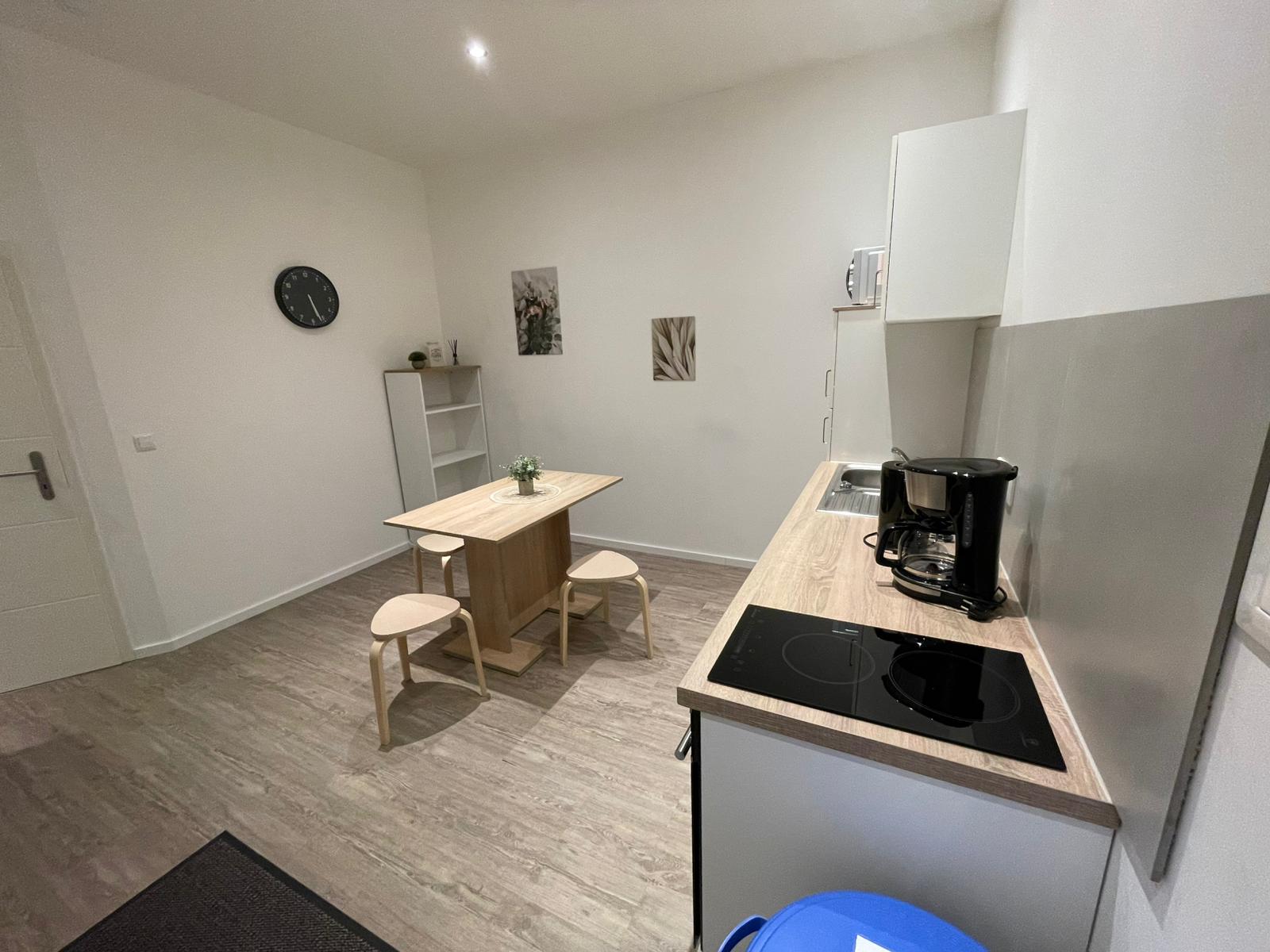 Küchenbereich mit Induktionsfeld, Kaffeemaschine und Essplatz – Vilstal Apartment 3 in Reisbach/Altersberg