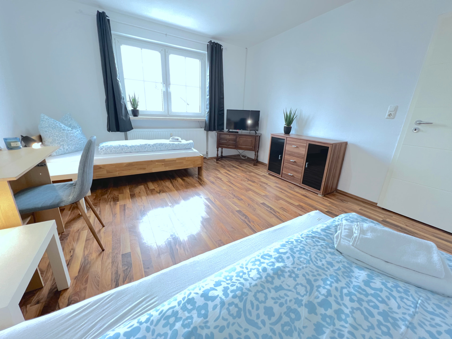 Apartment V in Dingolfing – Zimmer mit zwei Betten, Schreibtisch, TV und Kommode
