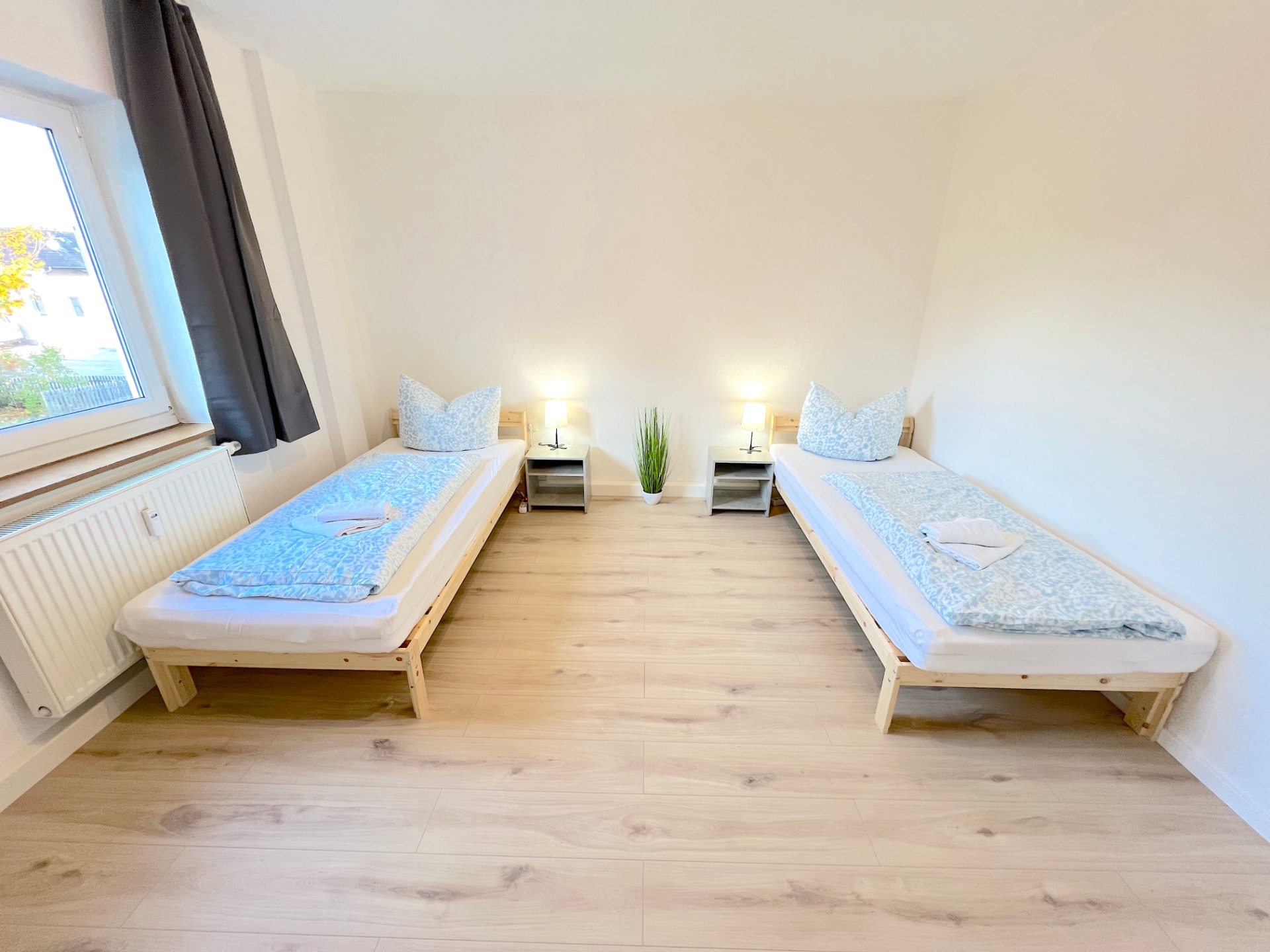 Zwei-Bett-Zimmer mit Nachttischen, Leselampen und Fenster in Apartment III Großköllnbach