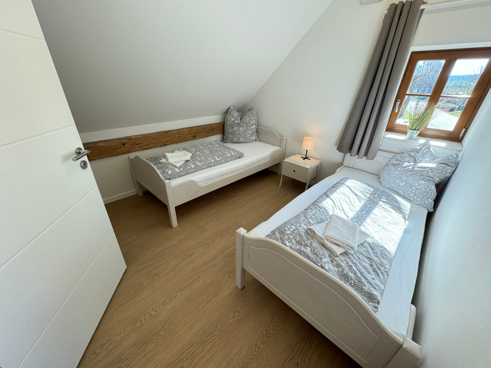 Zwei-Bett-Zimmer mit zwei Einzelbetten und Nachttisch in Apartment 3 Gottfrieding