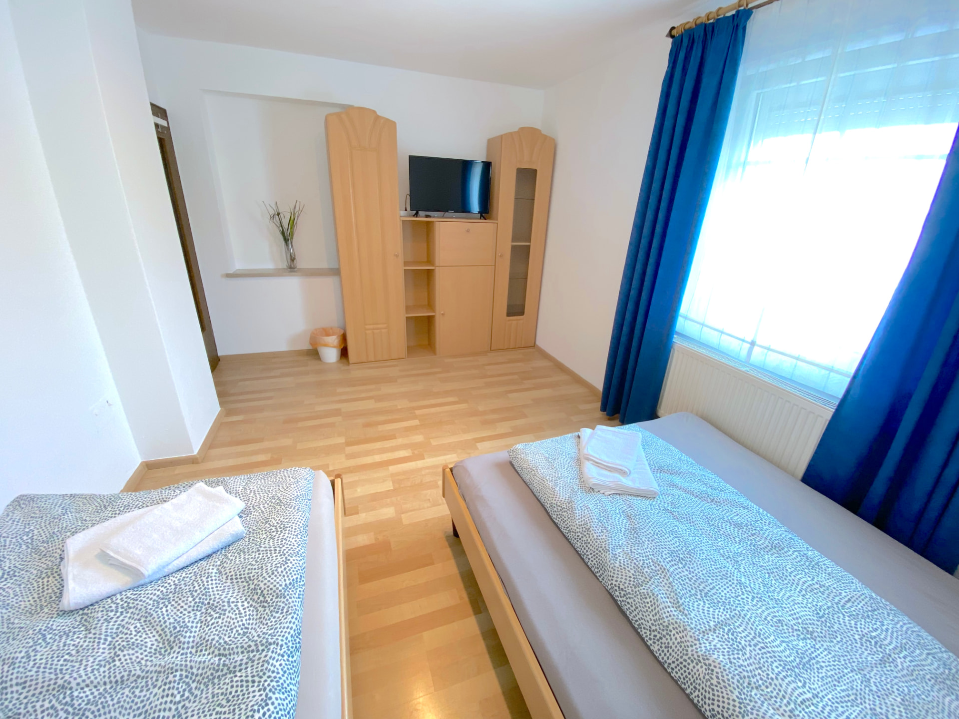 Apartment III in Kronwieden – Schlafzimmer mit zwei Betten, Schrankwand und TV
