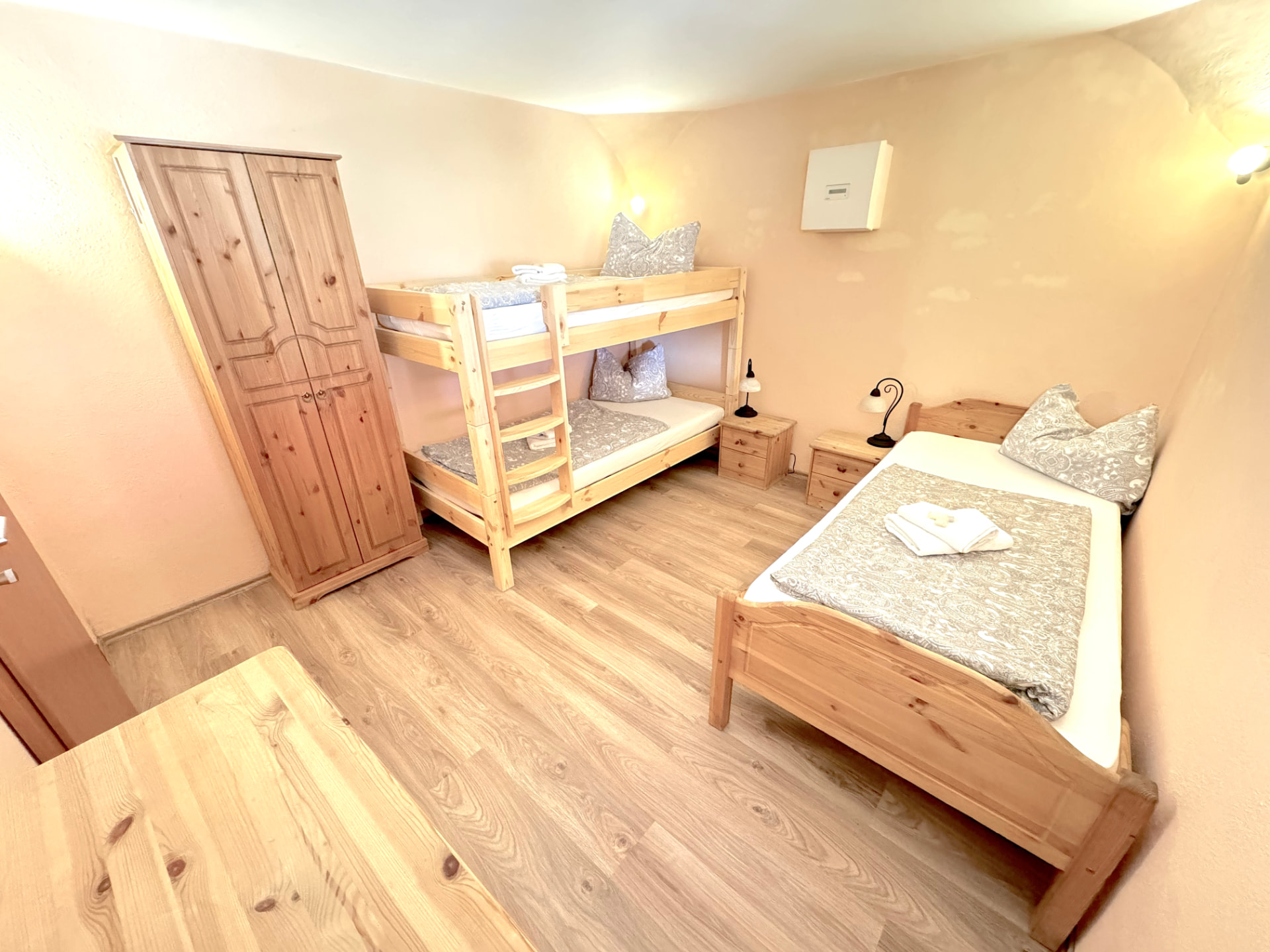 Drei-Bett-Zimmer mit Etagenbett, Einzelbett und Kleiderschrank in Apartment 0 Gottfrieding