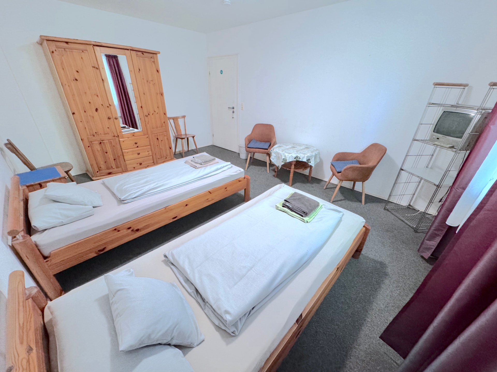 Zimmer mit zwei Einzelbetten, großem Kleiderschrank und Sitzgruppe in Apartment IV Mettenhausen