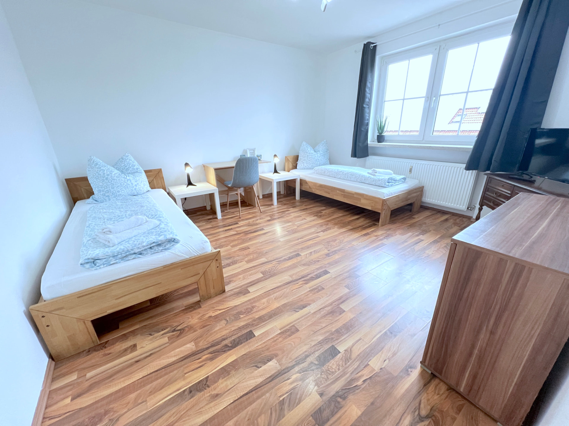 Apartment V in Dingolfing – Geräumiger Schlafraum mit zwei Einzelbetten und Arbeitsplatz