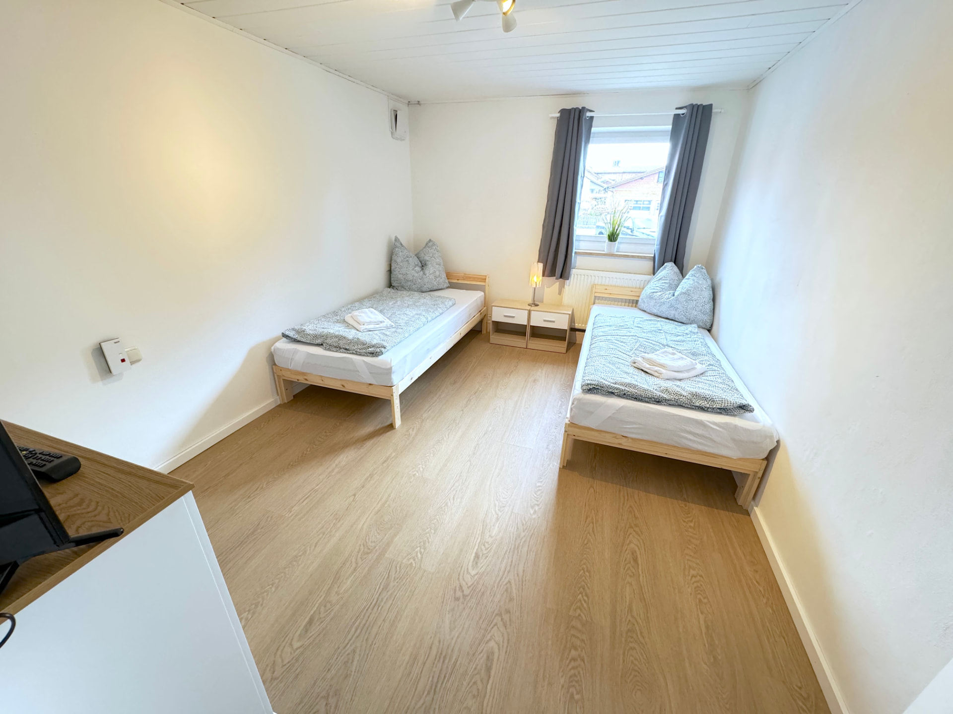 Apartmenthaus in Frontenhausen – Helles Schlafzimmer mit zwei Einzelbetten und Fenster