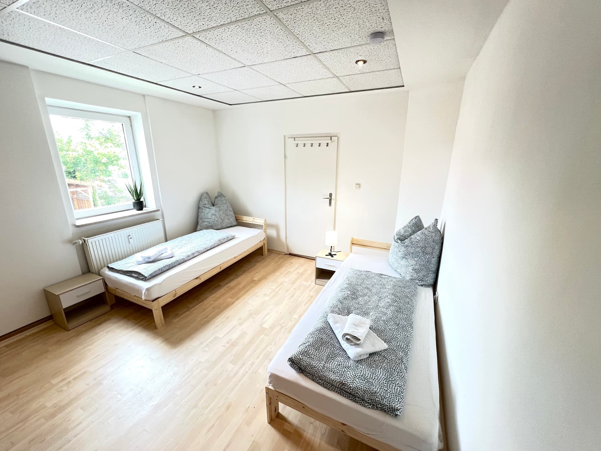 Zwei-Bett-Zimmer mit Fenster ins Grüne und Garderobe in Apartment I Großköllnbach