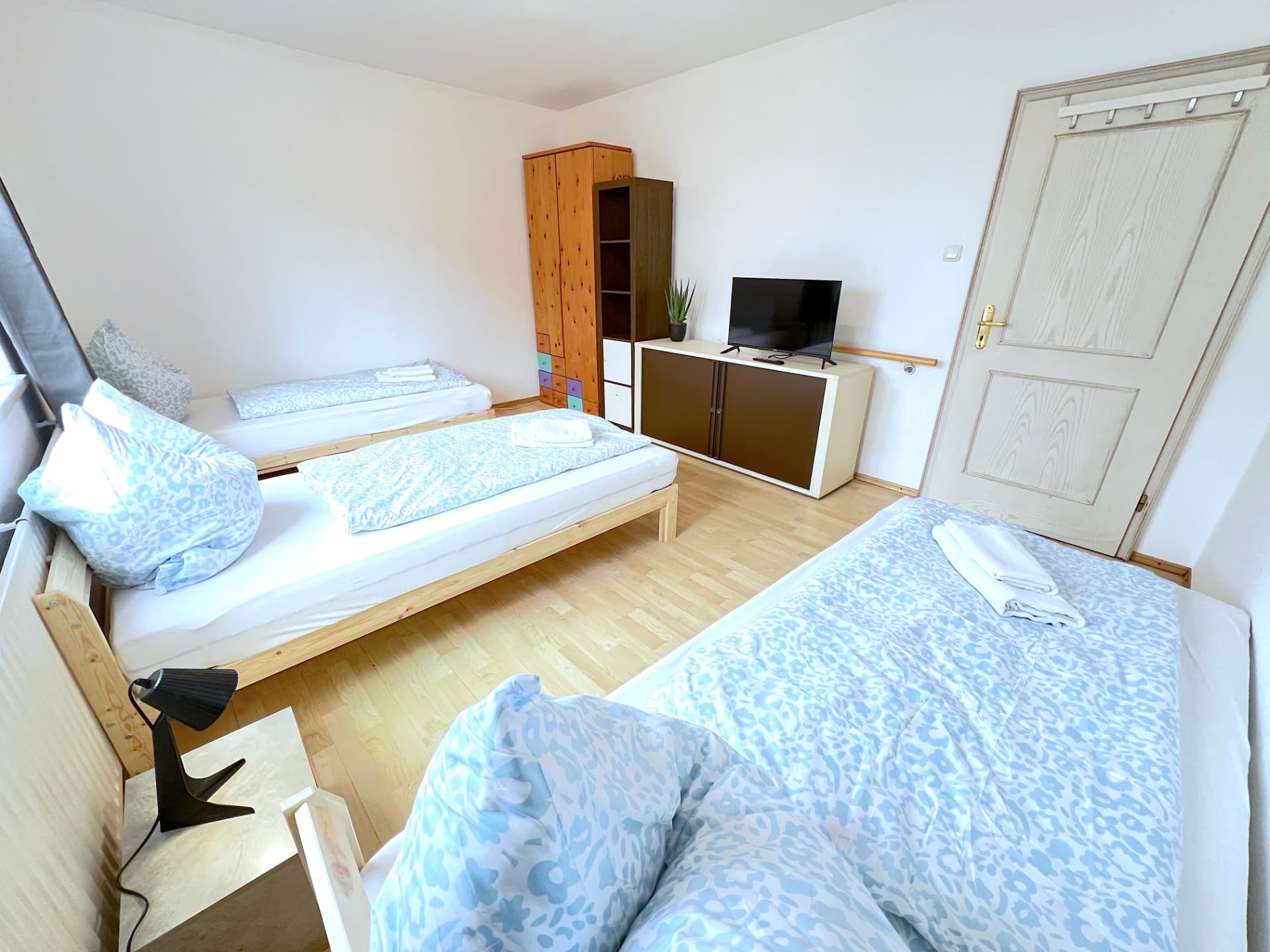 Apartment I in Dingolfing – Schlafzimmer mit vier Betten und TV