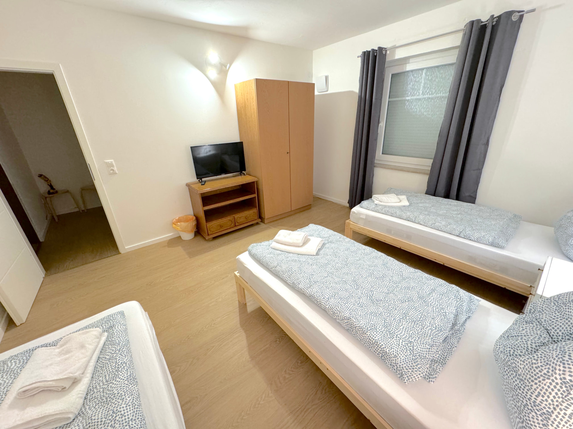 Apartment II in Kronwieden – Schlafzimmer mit Betten, Kleiderschrank und TV