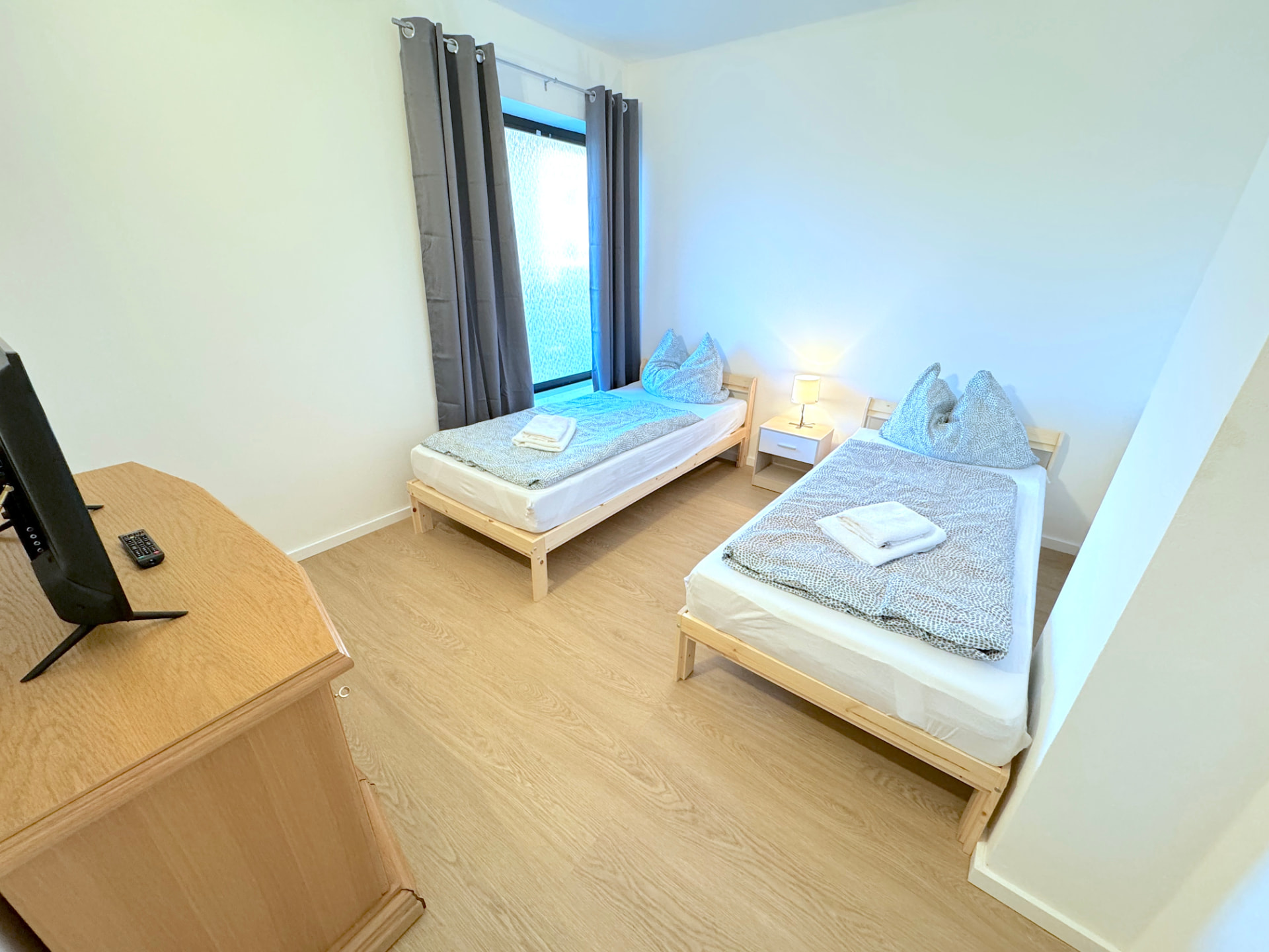 Apartment I in Kronwieden – Schlafzimmer mit zwei Betten, TV und Nachttisch
