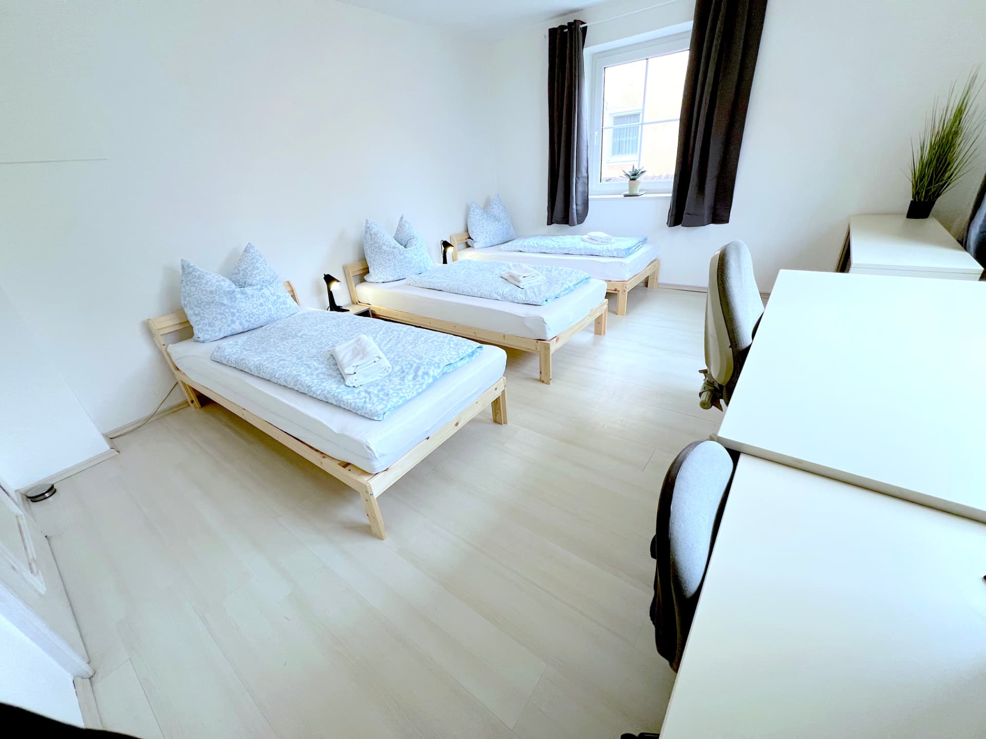 Apartment I in Dingolfing – Schlafraum mit drei Betten und Arbeitsplatz