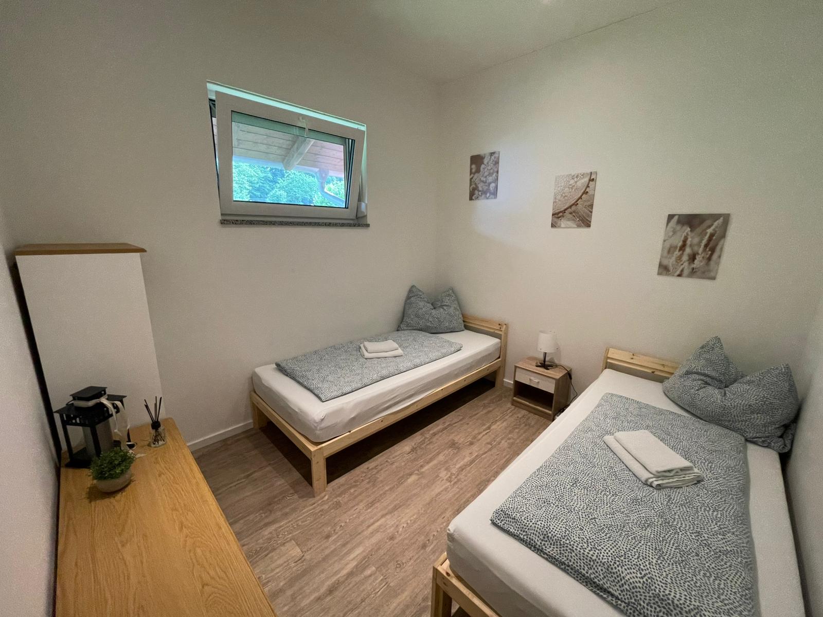 Zwei-Bett-Zimmer mit Einzelbetten, Nachttisch und Kommode – Vilstal Apartment 3 in Reisbach/Altersberg