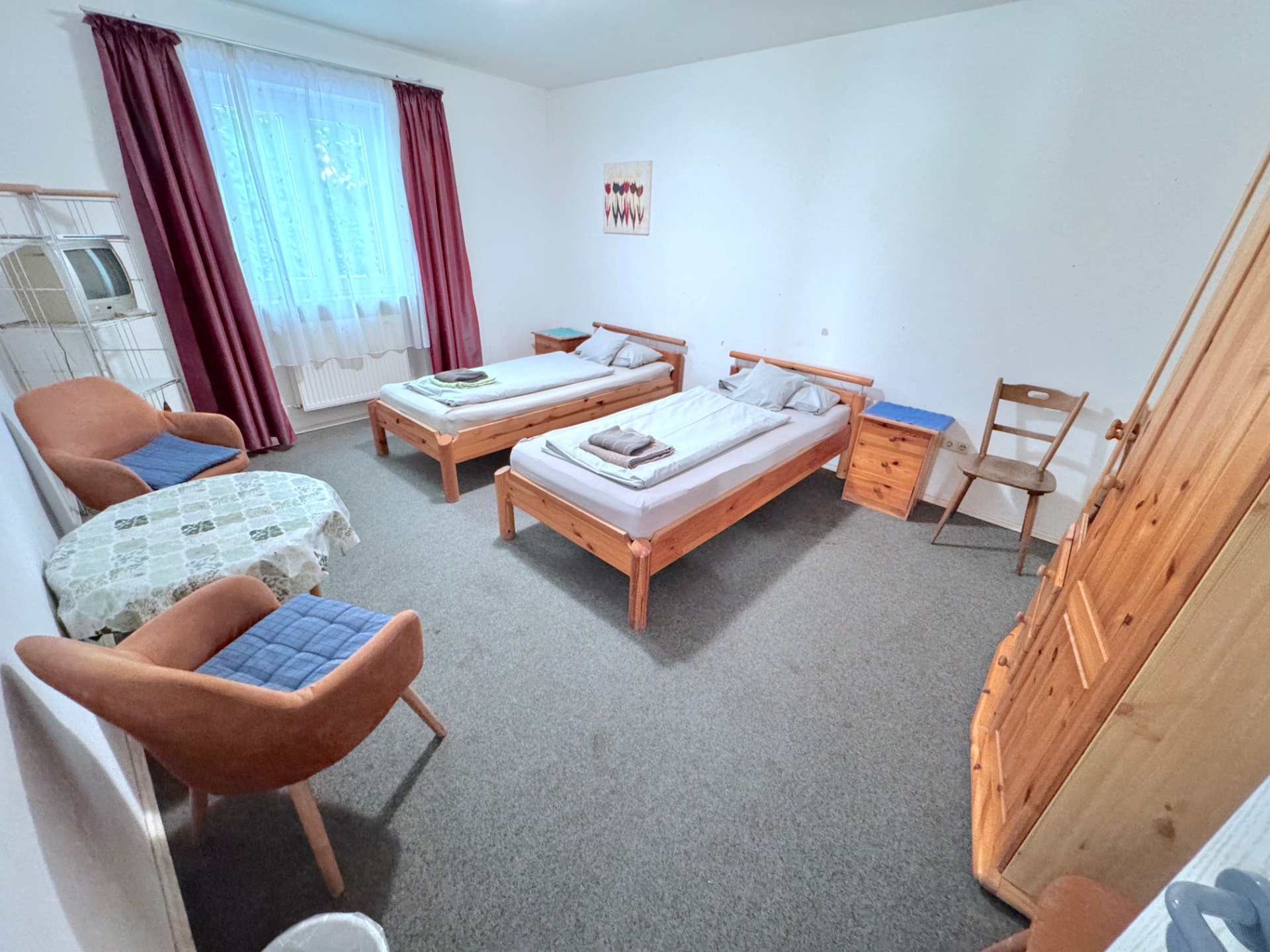 Geräumiges Zimmer mit zwei Einzelbetten, Sesseln und Tisch in Apartment IV Mettenhausen